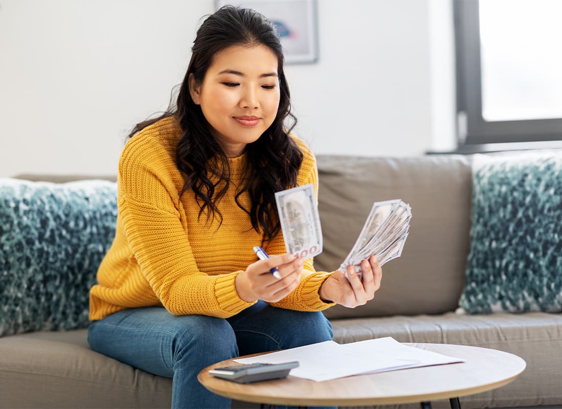 Things You Can Do Now to Strengthen Your Family’s Future Financial Health - Accounting, Taxes and Finances Concept - Young Asian Woman With Papers and Calculator Counting Money